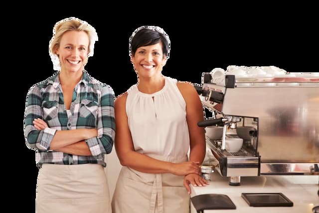 Two happy baristas next to an espresso machine